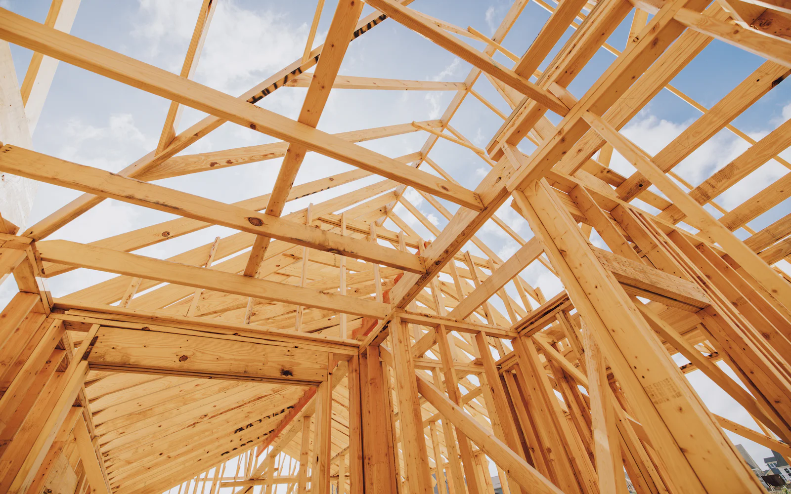 Timber roof framing against a blue sky on a building site