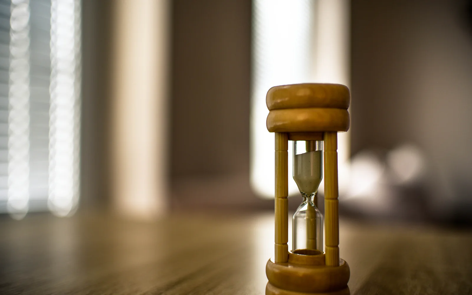 A wooden sand timer standing on a timber floor