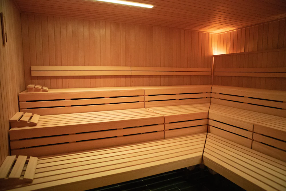 Three tiers of slatted benches in an empty timber sauna